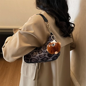 Borsa sottobraccio leopardata di tendenza con catena dorata e ciondolo di peluche