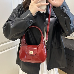 Red patent leather semi-circular handbag with gold clasp for winter fashion styles