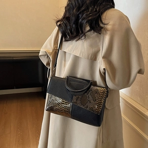 Chic 2025 retro snakeskin patchwork crossbody bag worn by model in minimalist beige coat