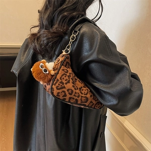 Borsa sottobraccio leopardata con catena dorata e ciondolo di peluche su giacca in pelle