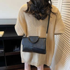Women's black faux snakeskin patchwork crossbody bag with silver metal ring handle