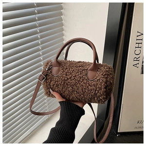 Dettaglio borsa cilindrica in pile teddy marrone con tracolla in pelle regolabile
