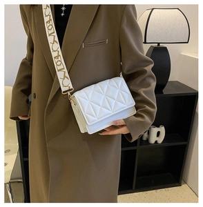 Chic white quilted crossbody bag with stylish wide patterned shoulder strap detail