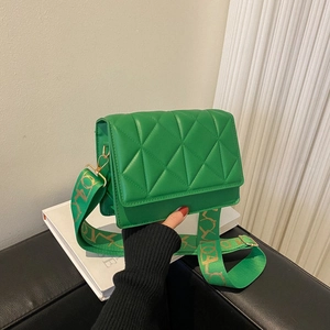 Green quilted flap crossbody bag with a wide patterned strap and golden hardware