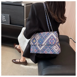 Detail of bohemian jacquard woven shoulder bag with colorful geometric patterns and chain strap