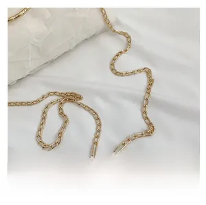 Close-up of elegant gold metal chain strap and pleated fabric texture on shoulder bag