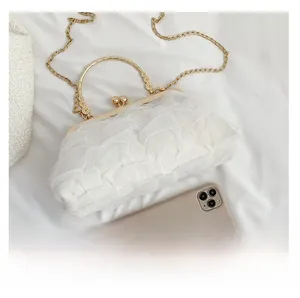 Detailed comparison of lace handbag size with a smartphone showing golden metal handles