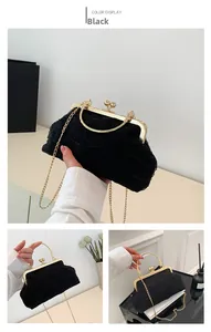 Close-up of black lace pleated evening bag with gold handle and detachable chain strap