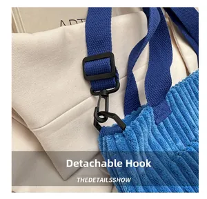 Dettaglio della borsa tote in velluto azzurro con ganci rimovibili e tracolla intrecciata