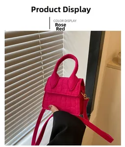 Detailopname van rozerode mini handtas van vilt met steenpatroon en smalle schouderriem