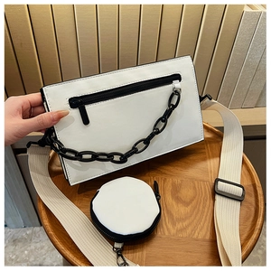 Detailed view of white PU leather square crossbody bag with black chain and wide strap