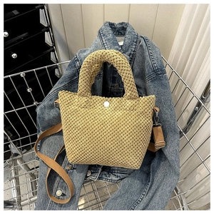 Primer plano del bolso saco de pana beige con textura y correa de tela marrón