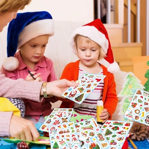 Close-up of children using colorful Christmas stickers with Santa and reindeer motifs