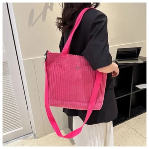 Dettaglio della borsa tote in velluto a coste rosa con tracolla e fibbia in metallo