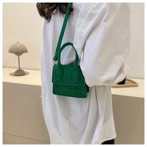 Mini groene crossbodytas met steenpatroon gedragen door een model over de schouder
