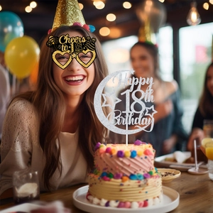 Detail of 18th birthday party set with glitter moon cake topper and heart glasses