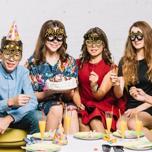 Detail of four black and gold 18th birthday party paper glasses on teens at a celebration