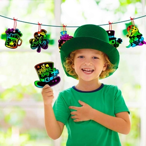 Kid showing St. Patrick's Day shamrock scratch ornaments with vibrant green designs