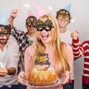 Group of young friends wearing black and gold 21st birthday party prop glasses and decor