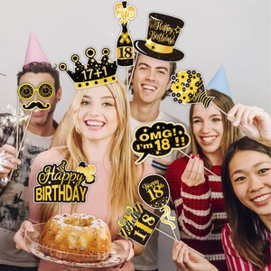 Black and gold 18th birthday photo booth props held by a group of happy young people
