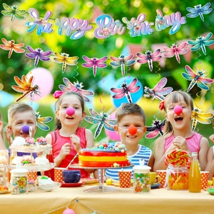 Kids celebrating birthday with dragonfly hanging swirls and Happy Birthday banner decor