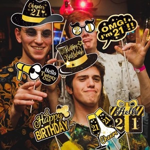 Close-up of 21st birthday photo booth props in elegant black and gold glitter design