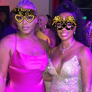 Close-up of golden glittery 40th birthday eyewear worn by guests in a lively party setting