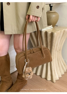 Détail du sac bandoulière rectangulaire marron vintage avec pendentif en peluche et poignées