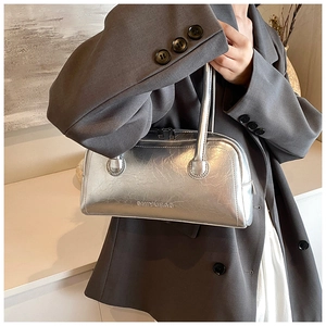Detail showing metallic silver textured leather and embossed logo on baguette shoulder bag
