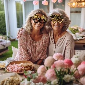 Detail of 50th birthday party glasses in black and gold with festive star accents