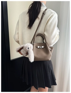 Brown leather Lindy style bucket bag with silver lock and plush rabbit charm detail
