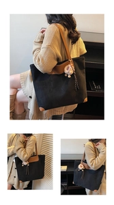 Detail of vintage suede tote bag with contrast leather trim and fluffy charm accessory