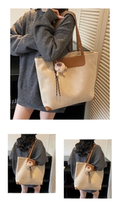 Detail of a large beige faux suede tote with brown leather trim and plush lamb charm