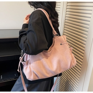Detalle del bolso tote de cuero rosa esmerilado con cordón lateral y bandolera