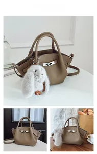 Detail of dark brown pebble leather bucket bag featuring a silver twist lock and bunny charm