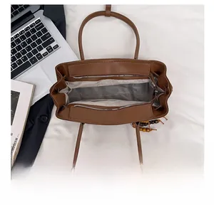 Interior view of brown suede tote bag showing large capacity space and zipper closure