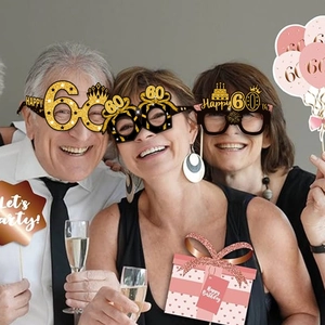 Detail of 60th birthday party glasses with black and gold glitter finish props