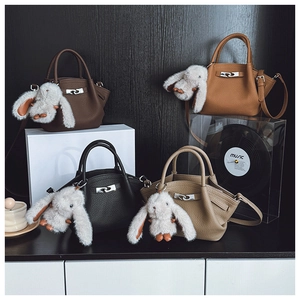 Detail of mini leather bucket bags in four colors with cute bunny charms and metal locks