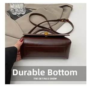 Detail showing the wear-resistant bottom and vintage golden lock of this leather handbag