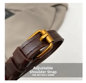Macro detail of dark brown leather adjustable shoulder strap with vintage brass buckle