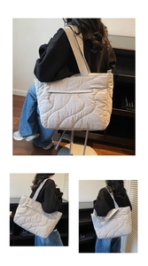 Detailed close-up of quilted wave pattern on a large off-white commuter tote bag