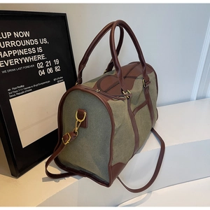 Close-up of olive canvas travel bag with leather straps on minimalist white steps