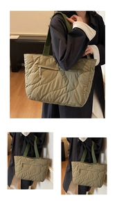 Macro view of wave quilted nylon tote bag with wide green straps and front zipper pocket