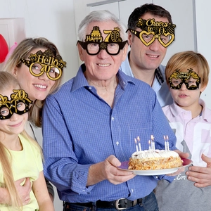 Close-up of black and gold 70th birthday party paper glasses with glittery finish