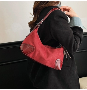 Dettaglio del materiale in camoscio rosso e finiture in pelle lucida di questa borsa retrò