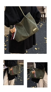 Detail of dark green matte leather tote bag with contrast stitching and bear charm