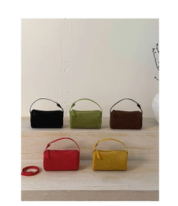 Minimalist bolster bags in suede texture showing diverse colors on stone steps