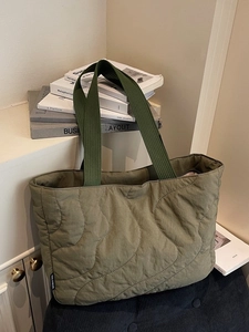 Olive green quilted shoulder bag with wave patterns and comfortable woven top handles