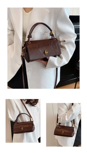 Detail of dark brown leather handbag featuring gold twist lock and textured finish