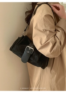 Gros plan d'un sac à bandoulière en daim noir avec boucle métallique argentée vintage